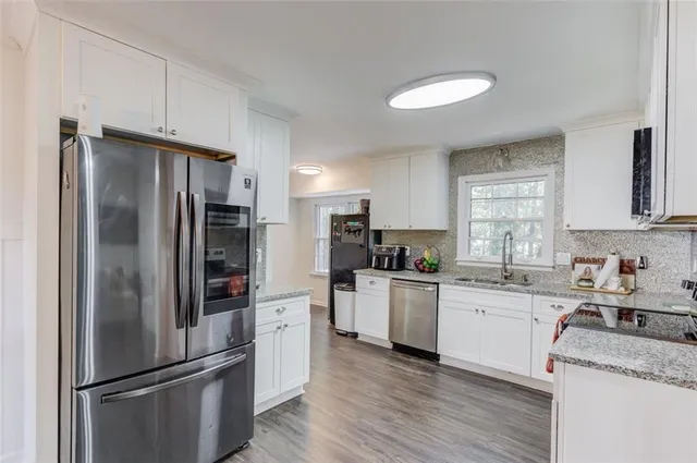 a kitchen with stainless steel appliances granite countertop a refrigerator stove and sink