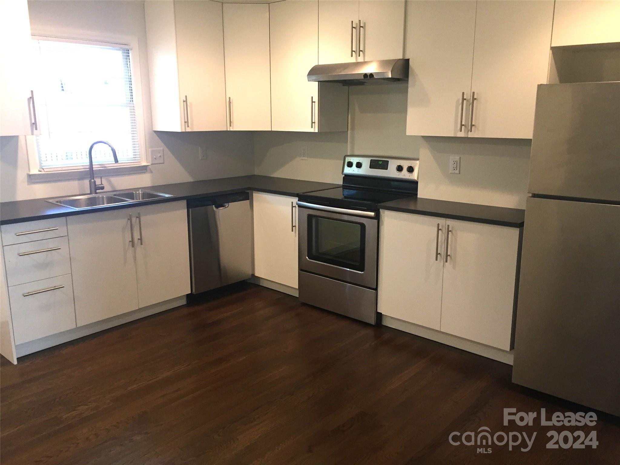 1824 Club Road Charlotte, NC 28205 - Photo 4 of 11 a kitchen with granite countertop a sink a stove and cabinets