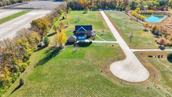 an aerial view of a house with a yard and lake view
