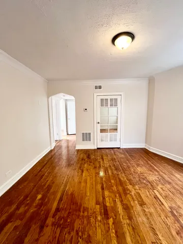 an empty room with wooden floor and window