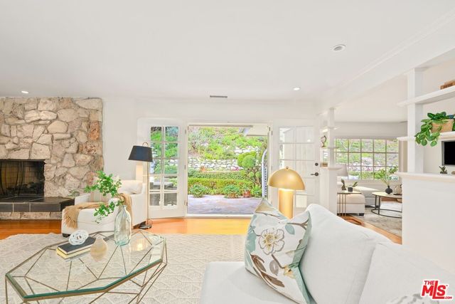 a living room with fireplace furniture and a large window