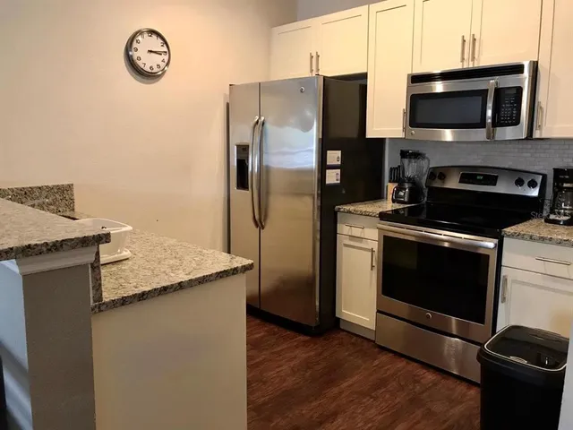 a kitchen with granite countertop a stove and a microwave