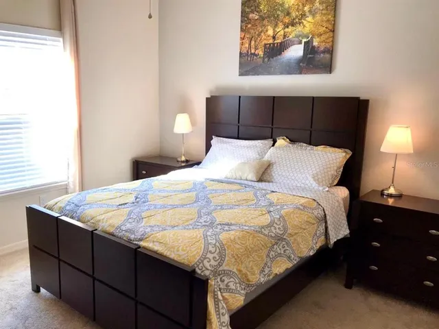 a bed sitting in a bedroom next to a lamp