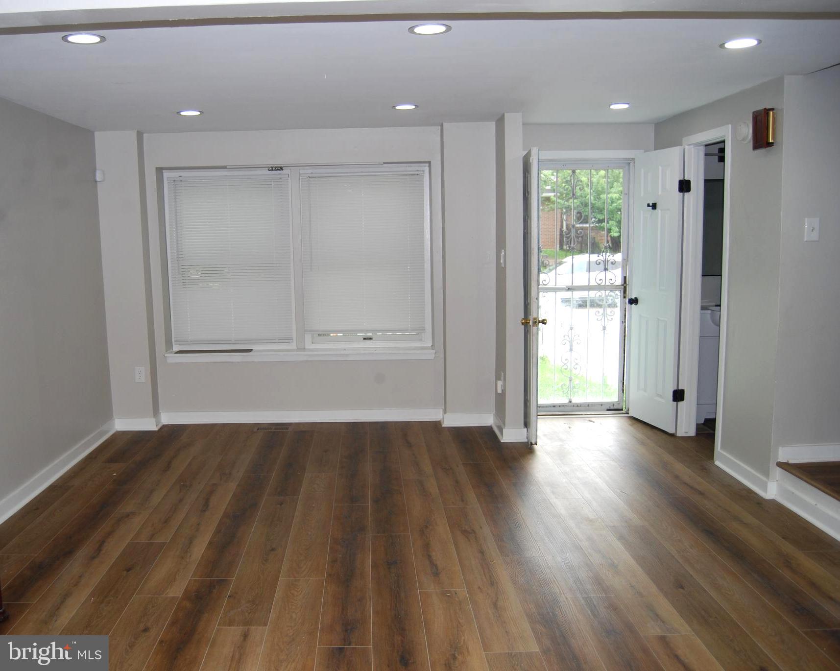 2400 Ridgely Street Baltimore, MD 21230 - Photo 2 of 20 a view of an empty room with wooden floor and a kitchen