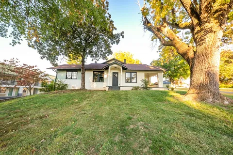 a front view of a house with yard and green space