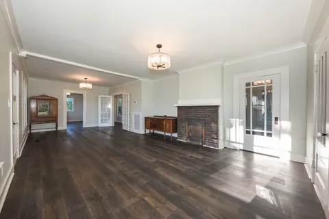 a view of a livingroom with wooden floor and a fireplace
