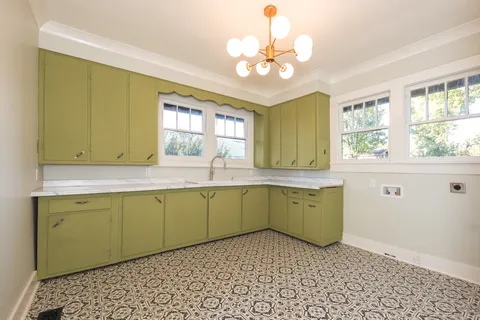 a kitchen with a sink window and cabinets