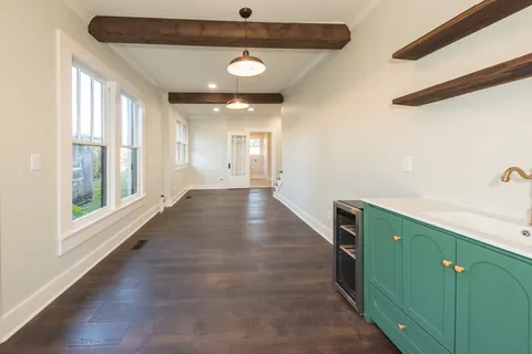 a view of a hallway with wooden floor and staircase