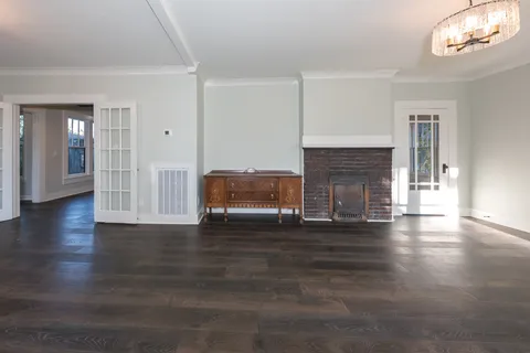 a view of empty room with fireplace and wooden floor
