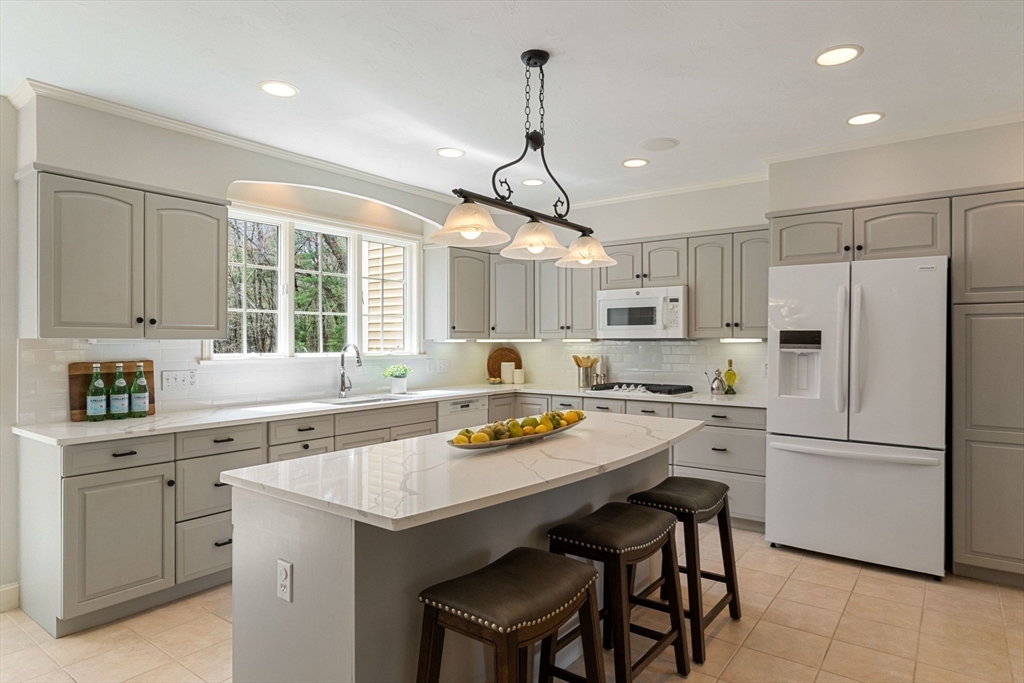 19 Buttonwood Drive Andover, MA 01810 - Photo 4 of 42 a kitchen with a refrigerator a sink dishwasher a stove and white cabinets with wooden floor