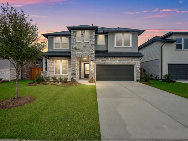 a front view of a house with a garden and yard
