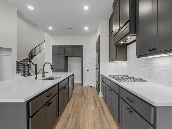 a kitchen with granite countertop a sink stove and cabinets