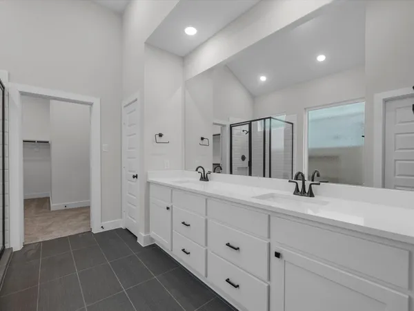 a bathroom with double sink and a mirror