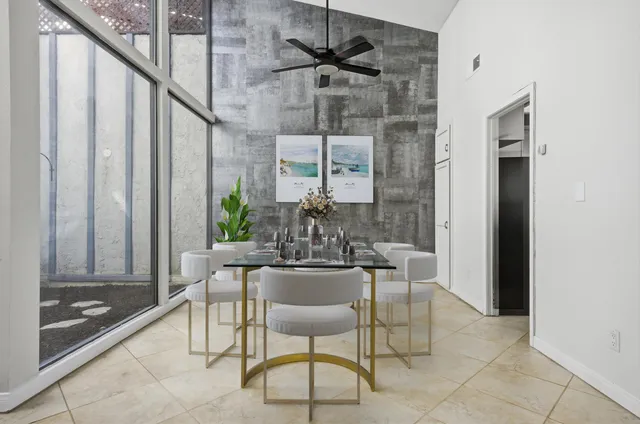 a dining room with furniture and a potted plant