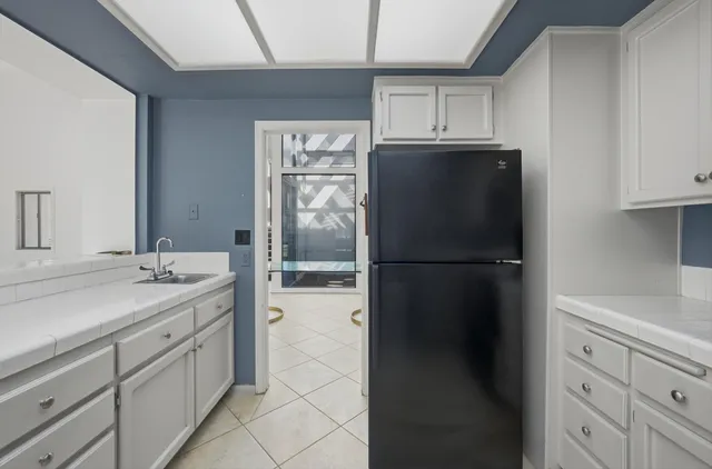 a kitchen with a refrigerator and cabinets