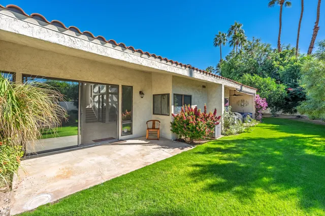 a view of a house with a yard and potted plants
