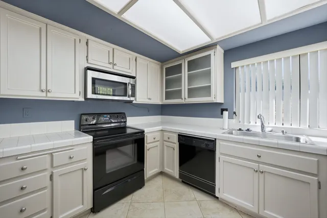 a kitchen with cabinets stainless steel appliances a sink and a microwave
