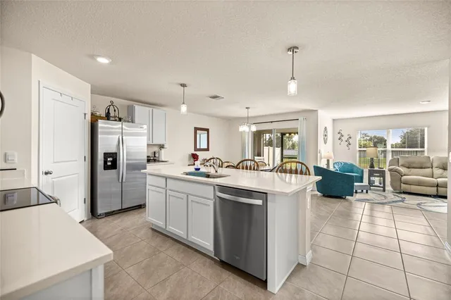 a kitchen that has a lot of white cabinets and stainless steel appliances