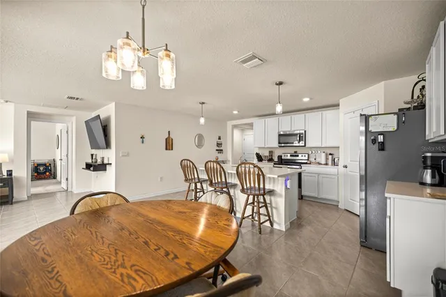 a living room with stainless steel appliances kitchen island granite countertop furniture and a dining table