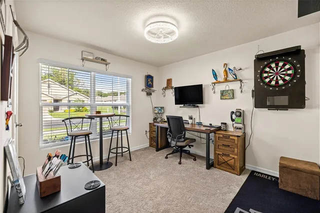 a view of a livingroom with workspace and a window