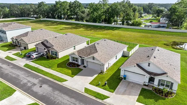 an aerial view of a house with swimming pool and yard