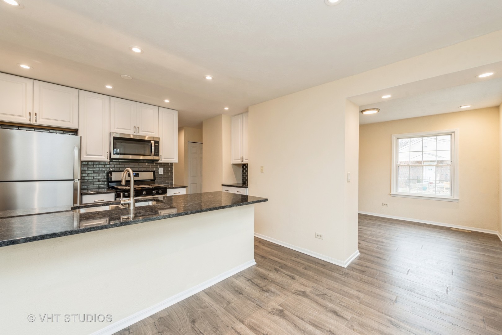 30 Hickory Lane Cary, IL 60013 - Photo 7 of 16 a kitchen with stainless steel appliances granite countertop a stove a sink a refrigerator white cabinets and wooden floor