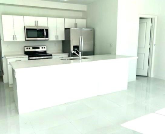 24650 Southwest 129th Avenue Homestead, FL 33032 - Photo 2 of 15 a living room with a flat screen tv and a refrigerator