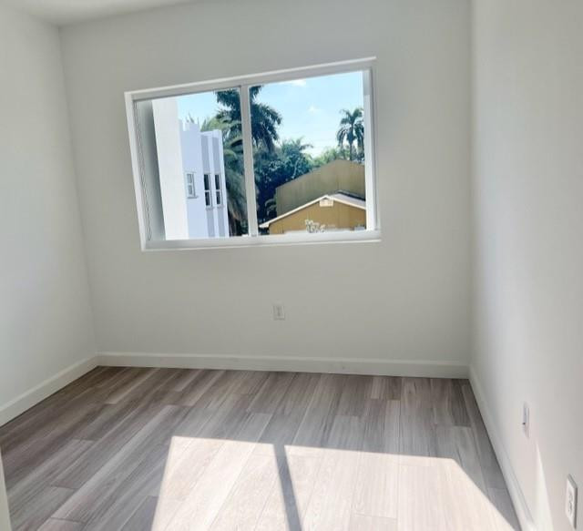 24650 Southwest 129th Avenue Homestead, FL 33032 - Photo 8 of 15 an empty room with wooden floor and a floor to ceiling window