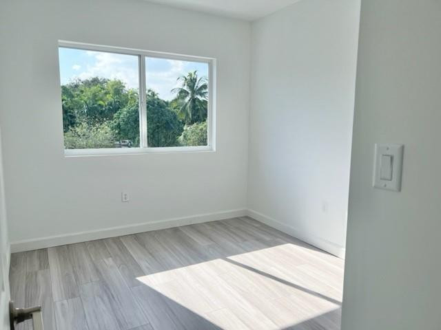 24650 Southwest 129th Avenue Homestead, FL 33032 - Photo 9 of 15 an empty room with wooden floor and windows