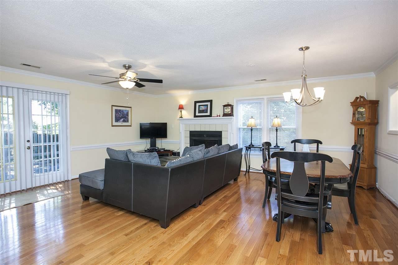 1500 Ferncliff Circle Raleigh, NC 27609 - Photo 5 of 25 a living room with furniture a dining table a lamp and a fireplace