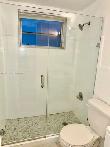 a bathroom with a toilet and a shower