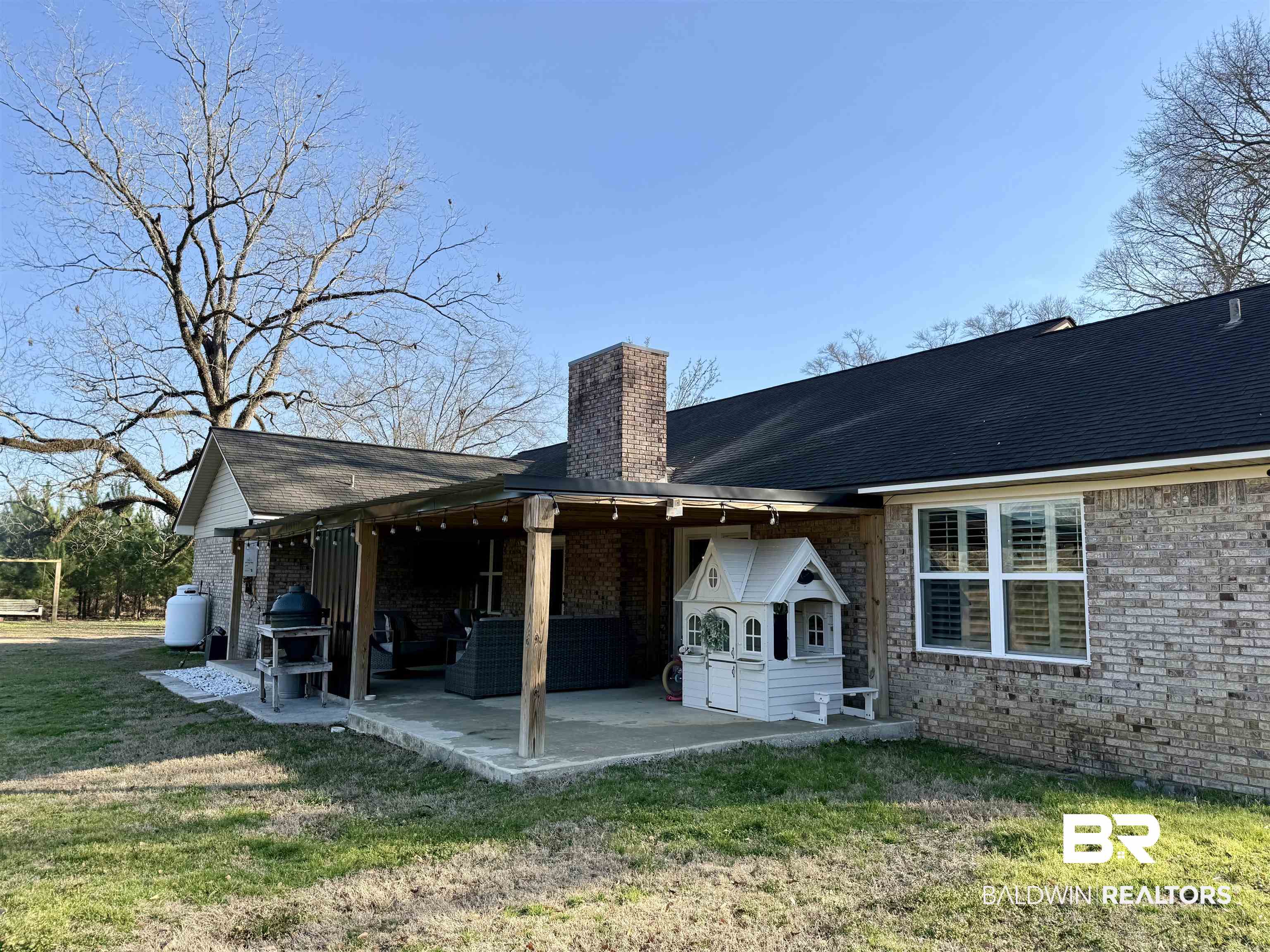 5646 Foshee Road Brewton, AL 36426 - Photo 27 of 37 Rear view of house with a patio, brick siding, a chimney, and a lawn