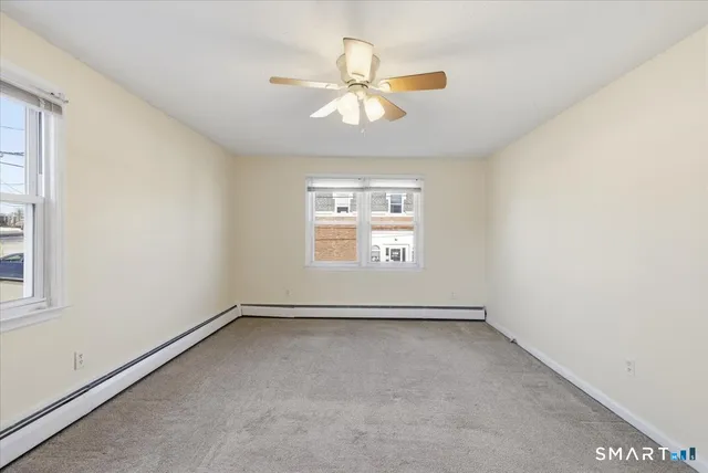 an empty room with windows and fan
