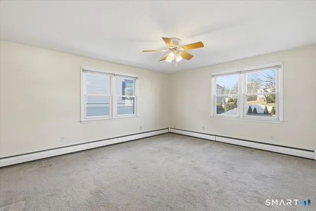 an empty room with windows and fan