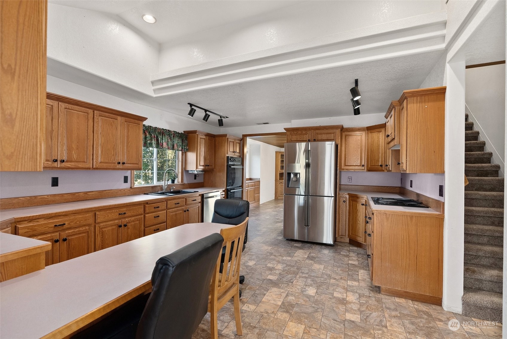 10441 Independence Road Southwest Rochester, WA 98579 - Photo 13 of 33 a large kitchen with a table chairs refrigerator and cabinets