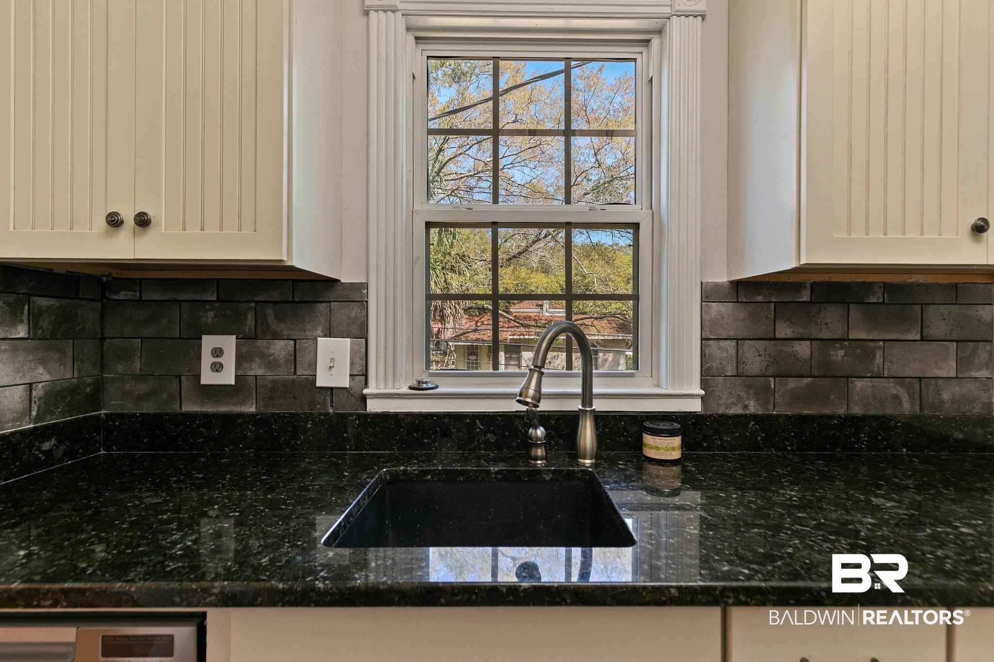 214 Upham Street, Unit 8D Mobile, AL 36607 - Photo 15 of 36 Kitchen featuring dark stone counters, white cabinets, and backsplash