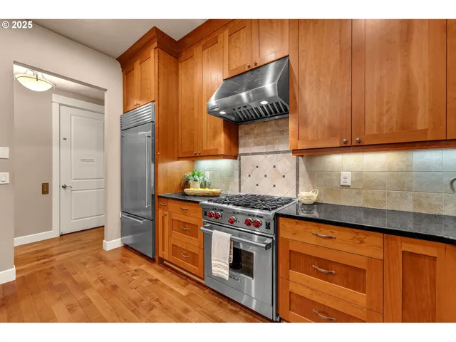 a kitchen with stainless steel appliances granite countertop a stove and a refrigerator
