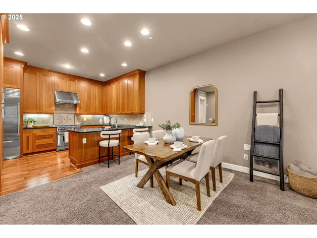 a living room with couches and kitchen view with wooden floor