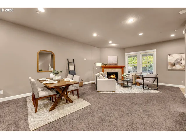 a living room with furniture a fireplace and a large window