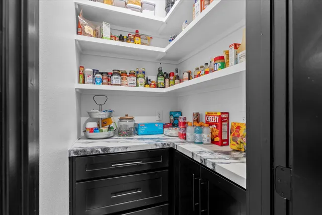 a utility room with lots of clutter and cabinets