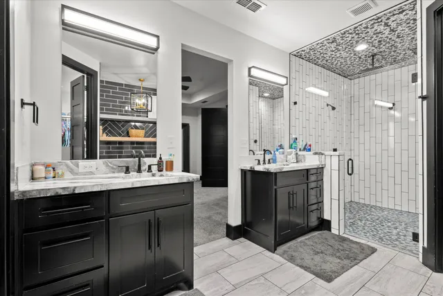 a bathroom with a sink shower and a mirror