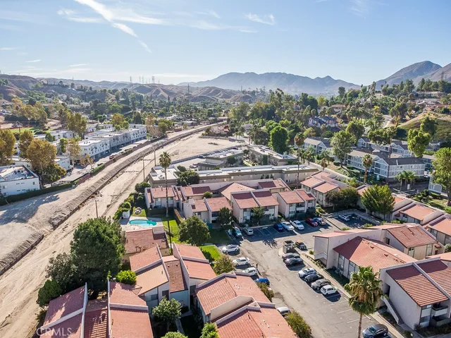an aerial view of a city with lots of residential buildings and mountain view in back