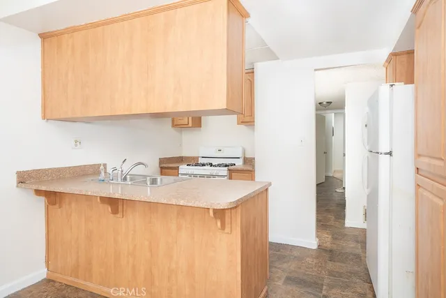 a kitchen with stainless steel appliances granite countertop a sink and a refrigerator