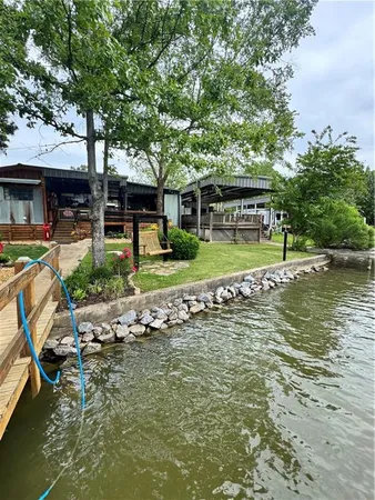 a view of a patio with table and chairs a barbeque in the water