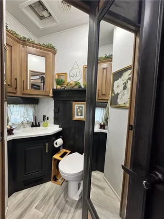 a bathroom with a toilet a sink and mirror