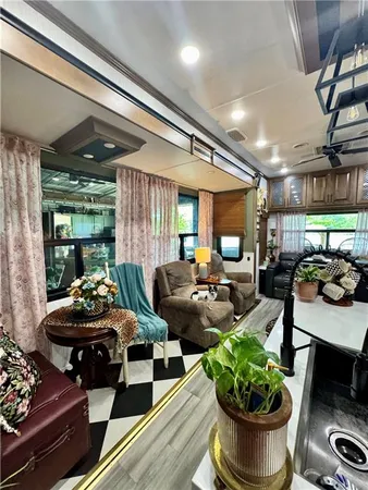 a living room with furniture potted plant and kitchen view
