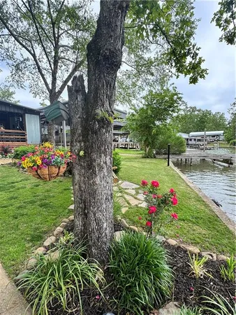 a view of a house with a big yard and large trees