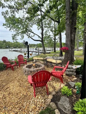 a view of a swimming pool with red chairs and a fire pit