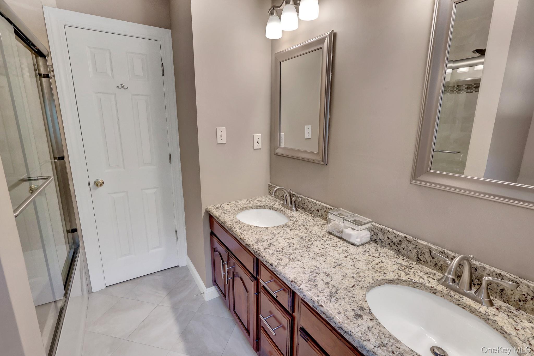 24 Fox Road East Setauket, NY 11733 - Photo 28 of 48 Double vanity with granite-style countertop, dual undermount sinks, and brushed nickel fixtures
