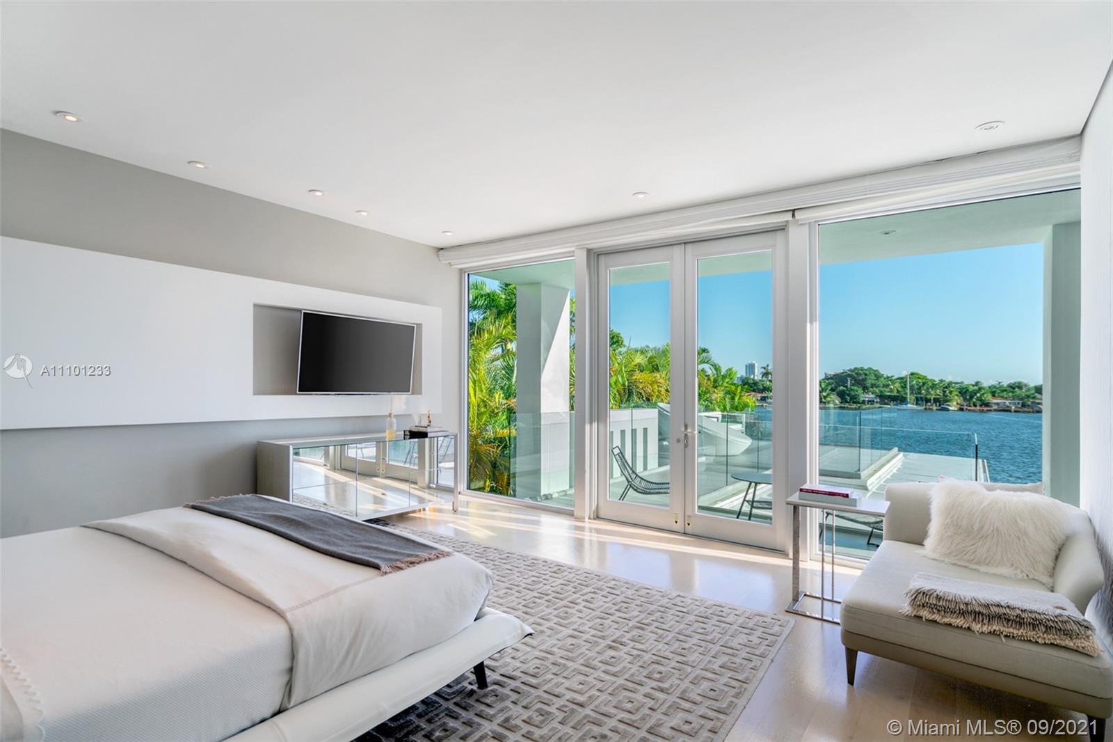 1236 Biscaya Drive Surfside, FL 33154 - Photo 21 of 40 a bedroom with a bed and glass window